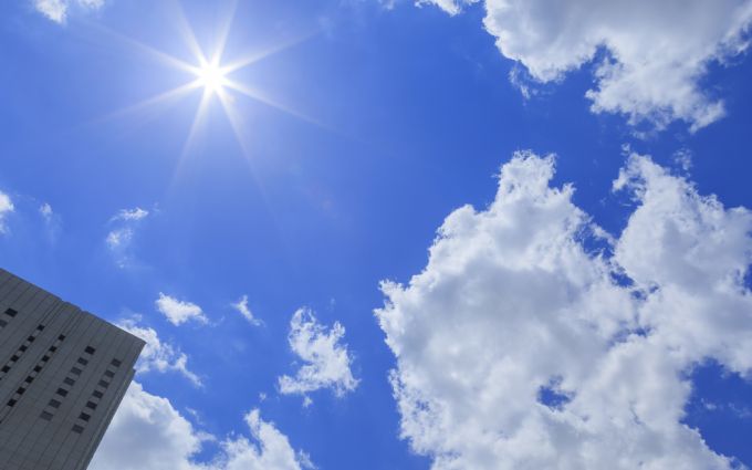 太陽の日差しと高層ビルの画像