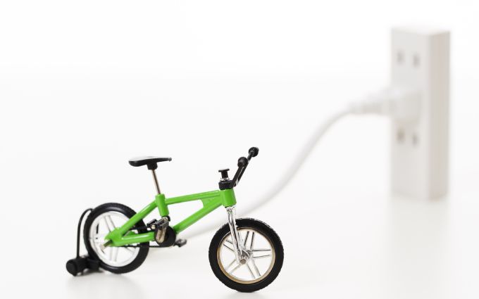ミニ電動自転車がコンセントに繋がっている画像
