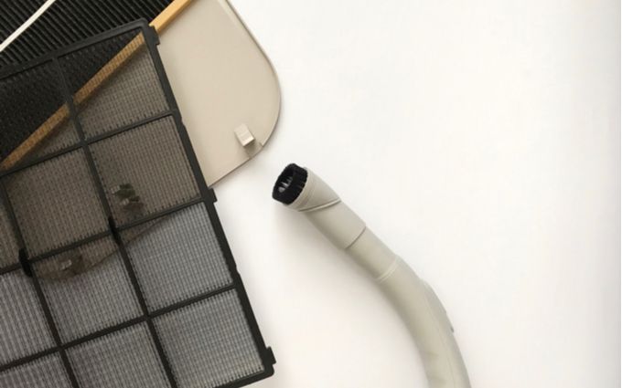 窓用エアコンのフィルターと掃除機の画像
