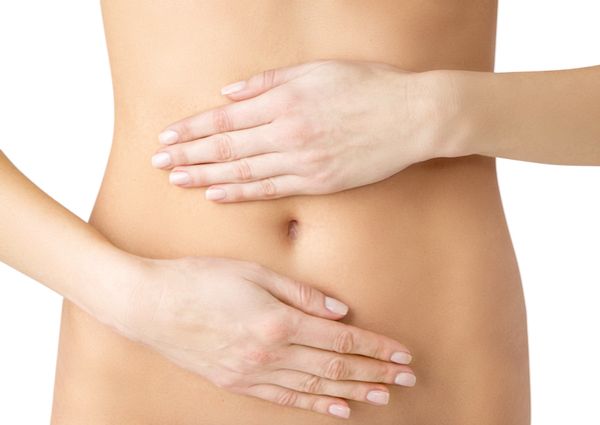 女性がお腹(腸)に手をあてている画像