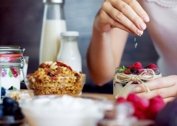 腸活のためにヨーグルトを食べている女性の画像