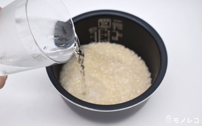 釜に入った腸活米に水を注いでいるシーンの画像