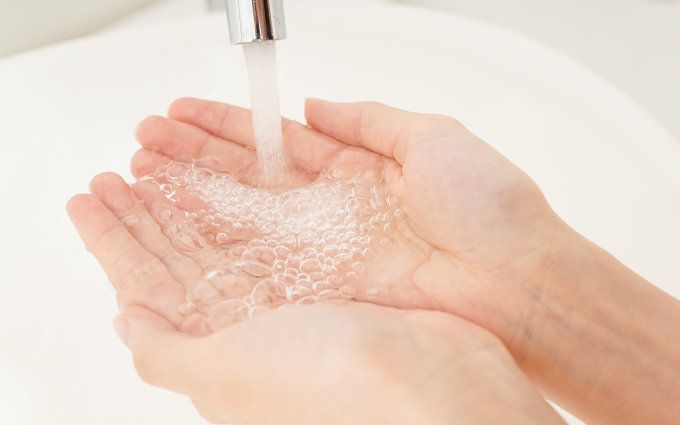クレンジングをする前に手を水に濡らしている画像