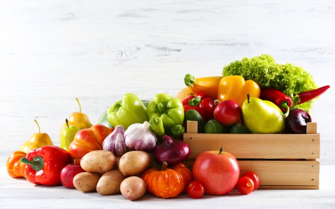 木箱からあふれんばかりの野菜や果物の画像