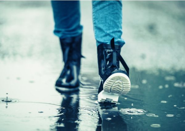 雨の中を歩く男性のレインブーツの画像