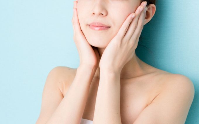 洗い上がりの肌を触る女性の画像