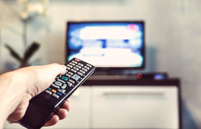 テレビのリモコンを操作している画像