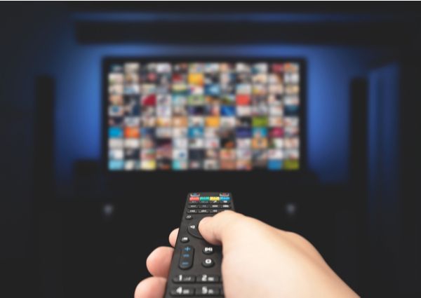 テレビリモコンをテレビに向け複数のメディアを選んでいる画像
