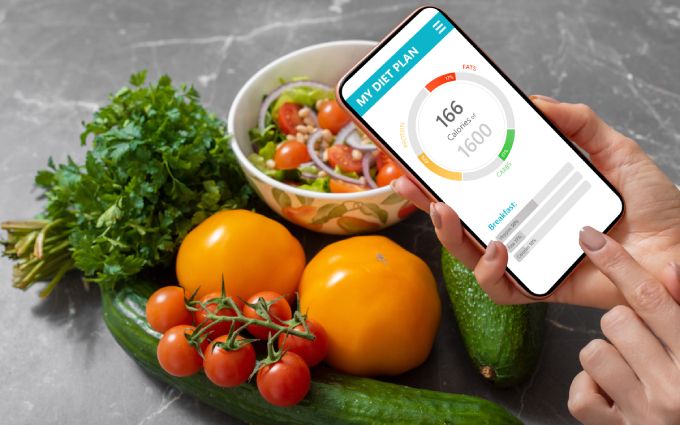 野菜とスマホでカロリー計算している人の手元の画像