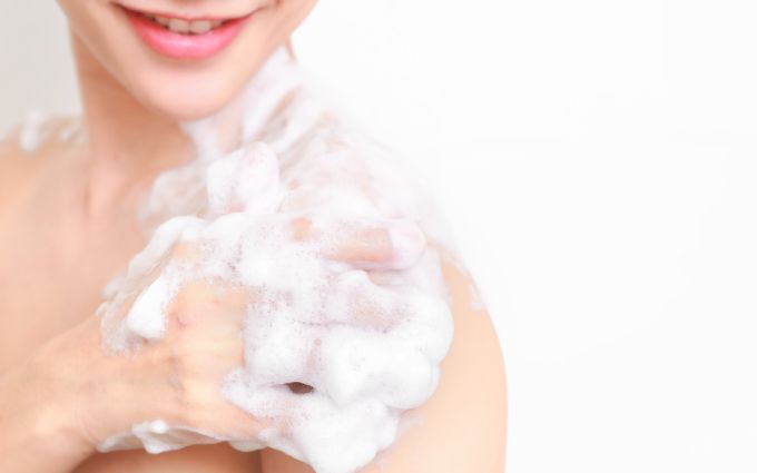 女性がもこもこの泡で体を洗っている画像