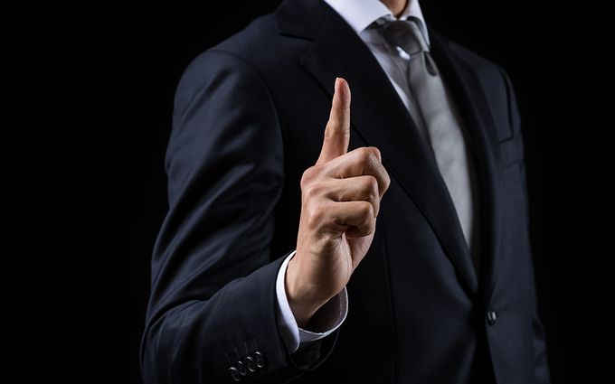 人差し指を立てる男性