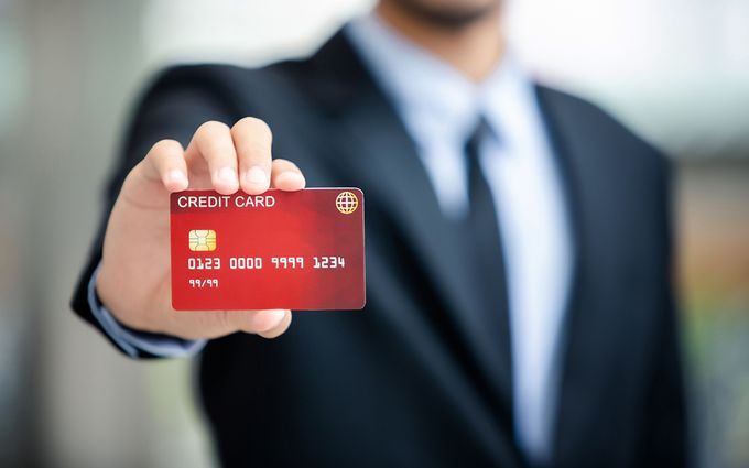 クレジットカードを見せる男性