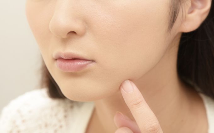 肌の悩みを気にしている女性の画像