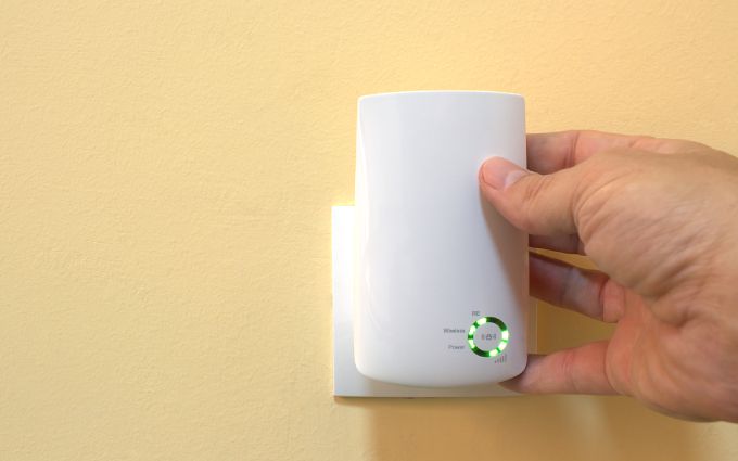 直挿しタイプのWi-Fi中継器をセットしている手元の画像