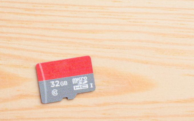 木の板に置かれた32GBのマイクロSDカードの画像