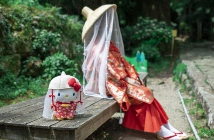 ふるさと納税限定のハローキティぬいぐるみと平安衣装を着た人